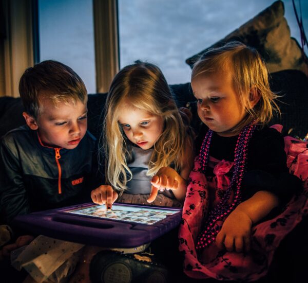 Three children starring at a screen