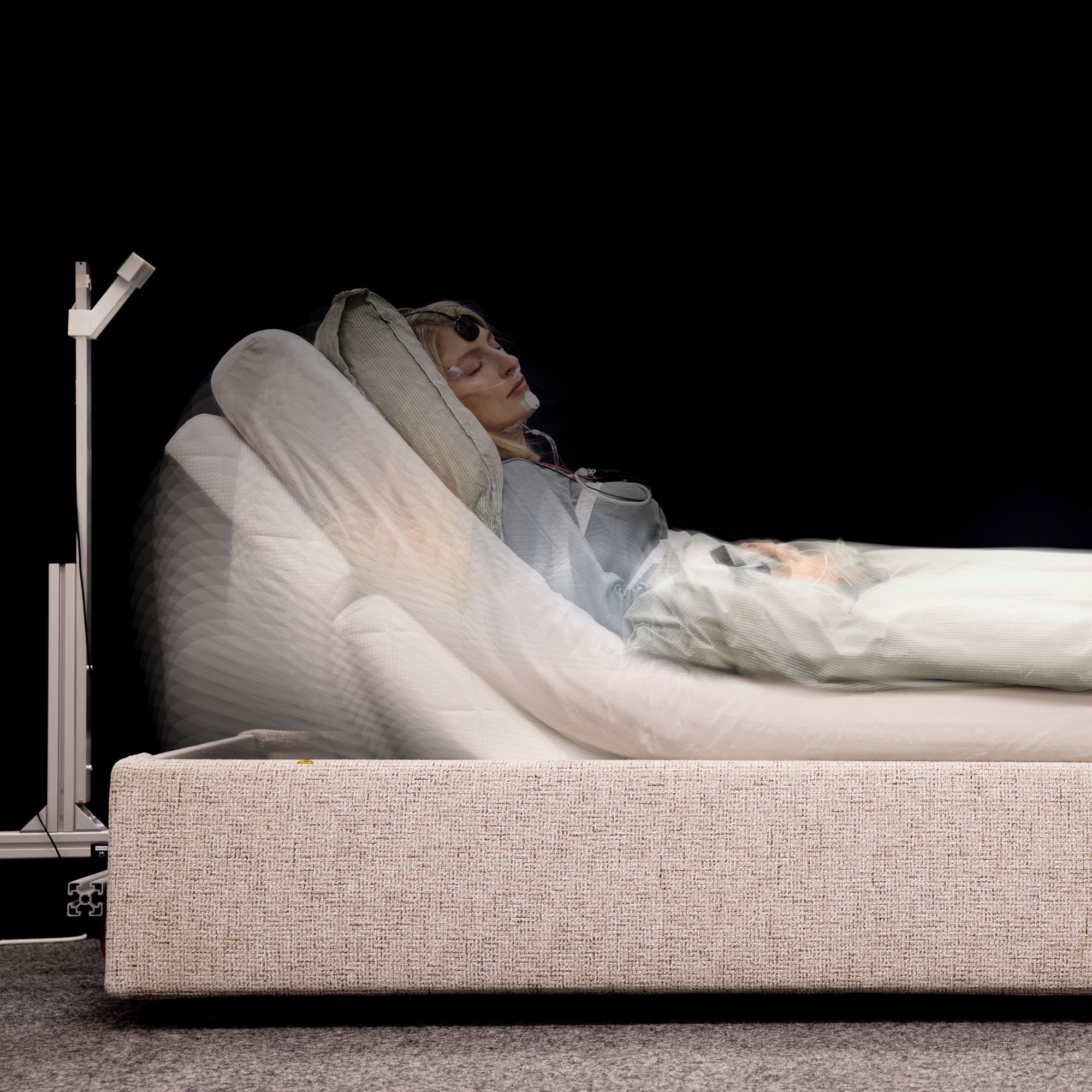 Woman lying in bed with a device monitoring her sleep