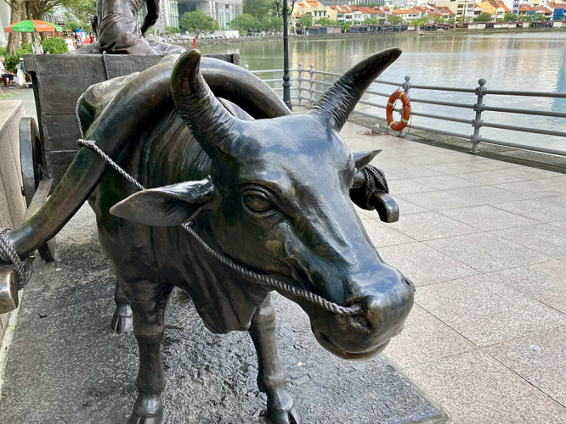 Bronze statue of a bullock pulling a cart along the Singapore River.